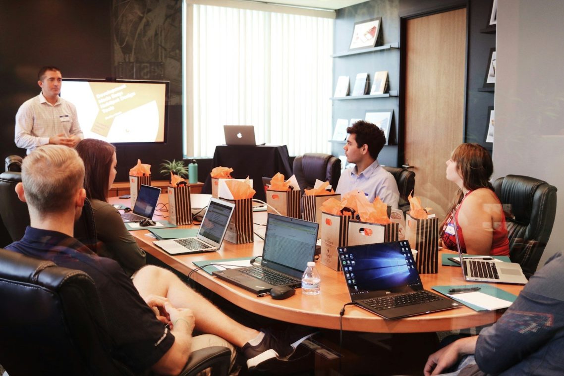 A business meeting with participants watching a presentation in a modern conference room.